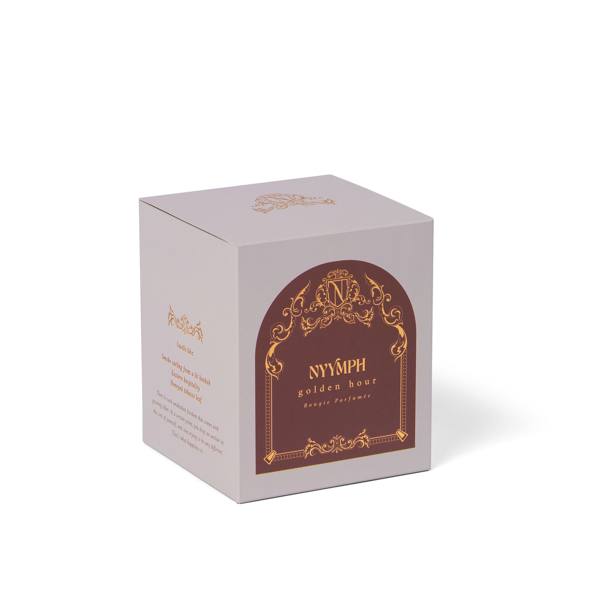 NYYMPH Golden Hour candle box – light grey packaging with ornate gold arch design, photographed at 3/4 angle.