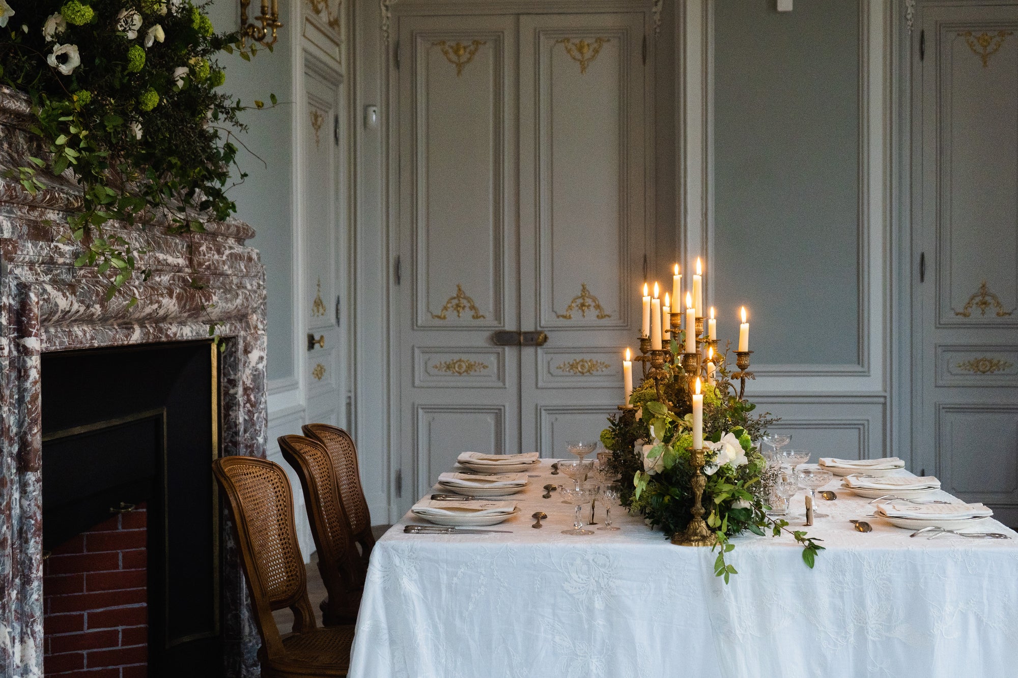 Candlelit luxury dining table set for an elegant soirée, with floral centrepiece and classic French interior decor, perfect for NYYMPH brand ambiance.